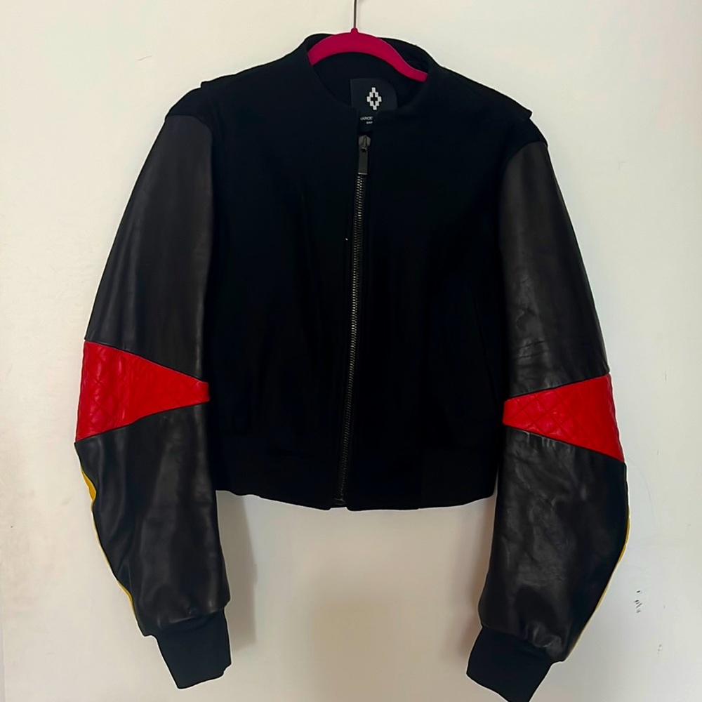 Black letterman jacket moto leather sleeves. Red & yellow piping. Red elbow.